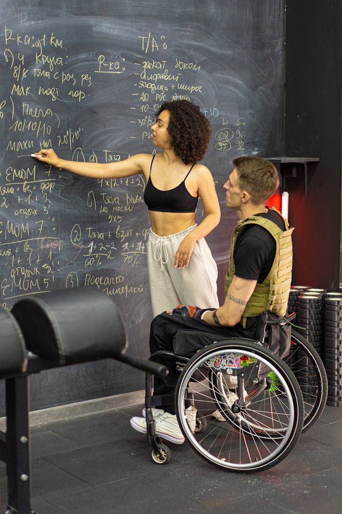 Two individuals engaged in learning with a blackboard, focusing on inclusive education and fitness.